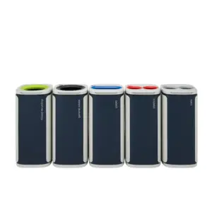 Five tall dark grey cylindrical bins with white accents stand side by side, each with vertical labels and coloured tops: green (mixed recycling), black (general waste), blue (paper), red (plastics), and grey (cans).