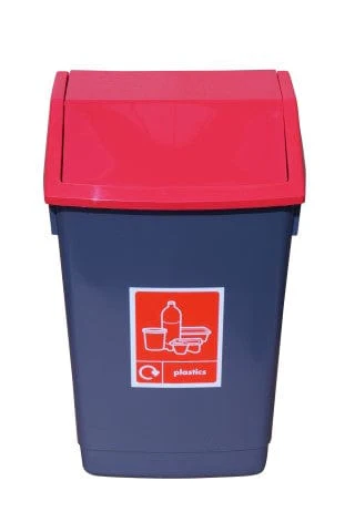 A dark grey bin with a red, angled lid is shown front-on, featuring a red and white label with a recycling symbol and icons for plastic items.
